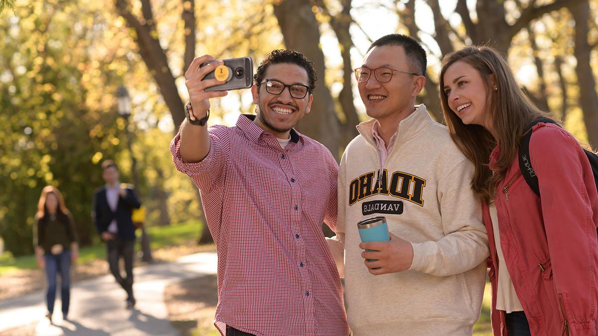 Three international students take a selfie on Hello Walk